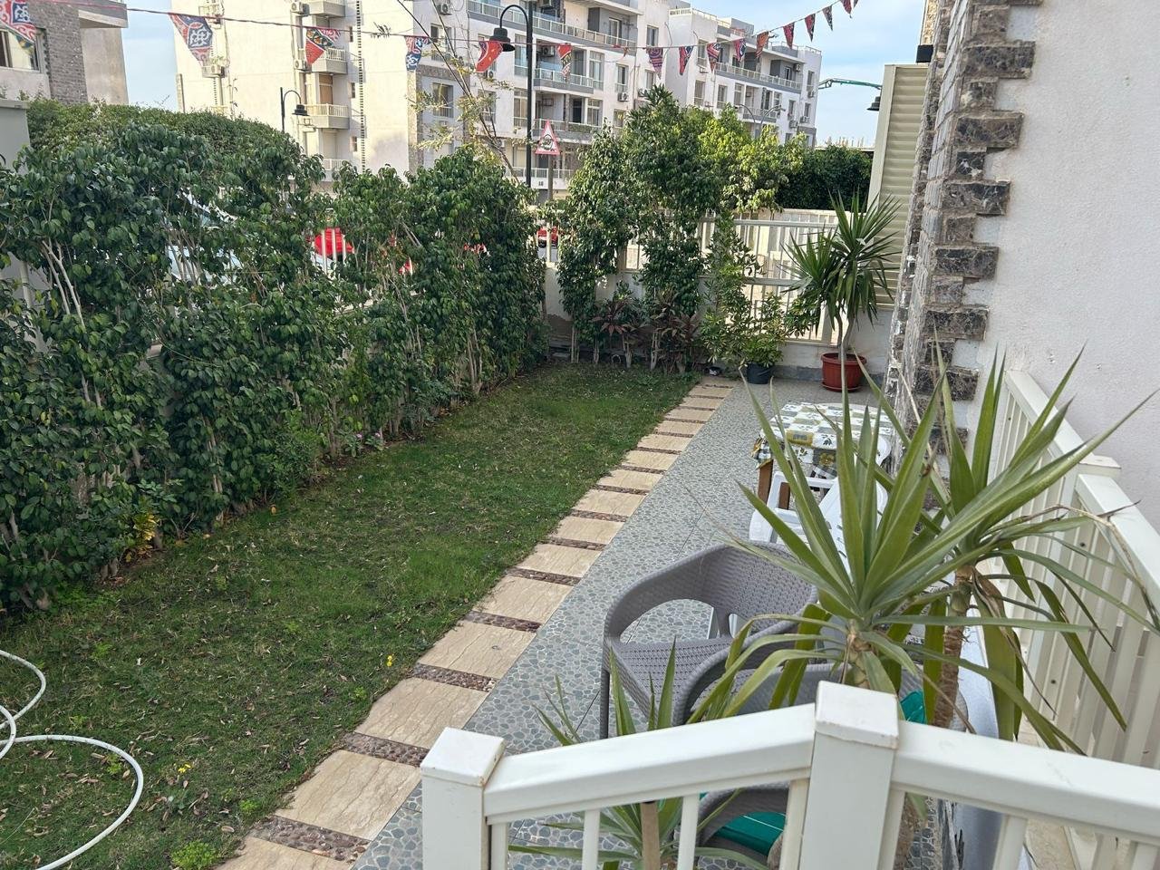Private garden with a stone path and a white railing - duplex in Jayd New Cairo – 3 Bedrooms 260 sqm with Private Garden, New Cairo
