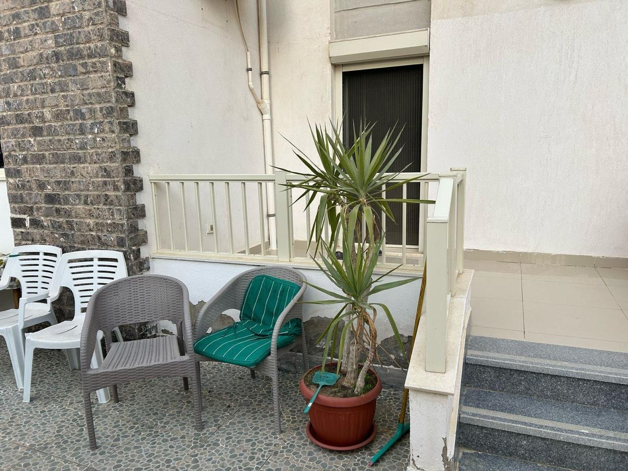 Garden terrace seating with a palm plant and steps - duplex in Jayd New Cairo – 3 Bedrooms 260 sqm with Private Garden, New Cairo