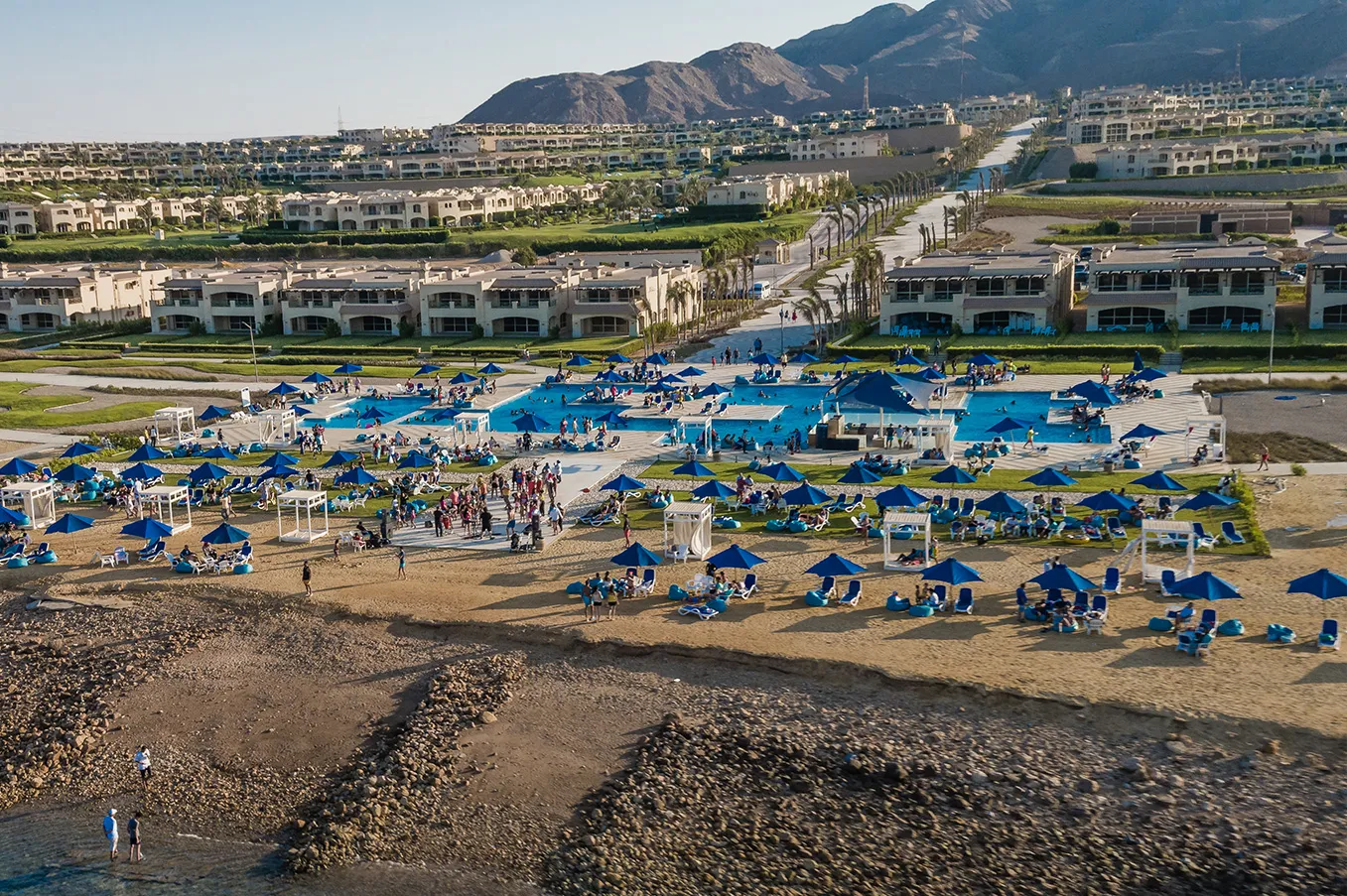 la-vista-6-developer-photo-2 إطلالة جوية على حمامات السباحة والشاطئ وخلفية الجبل - فيلا في لا فيستا 6، السويس
