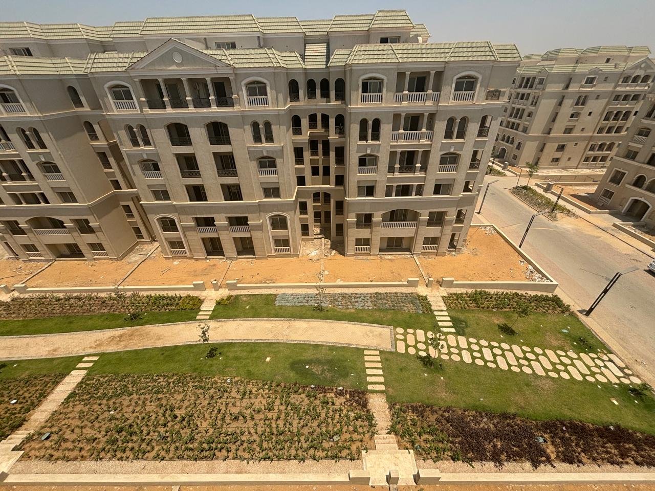 lav524-u9 Aerial view of apartment buildings and garden paths with stepping stones - apartment in L’avenir Sabbour, Mostaqbal City