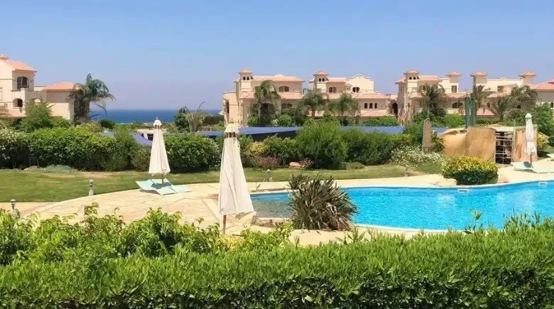 حمام سباحة بجوار مسطحات خضراء - شاليه في لافيستا 3 بالعين السخنة