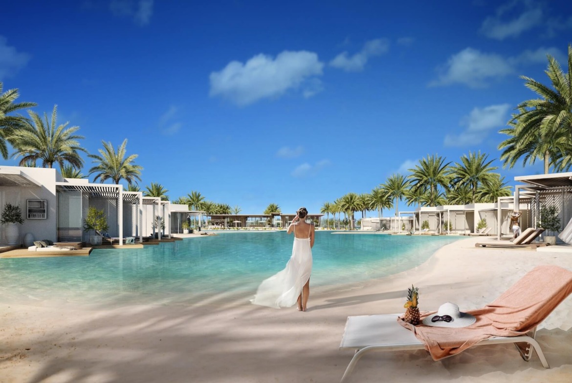 Woman walking on a sandy lagoon beach with a lounger - hotel apartment in Soul by Emaar, North Coast