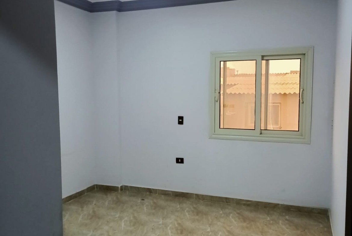 Empty room with light blue walls and a ceiling spotlight - apartment in South Lotus on South 90th Street, New Cairo