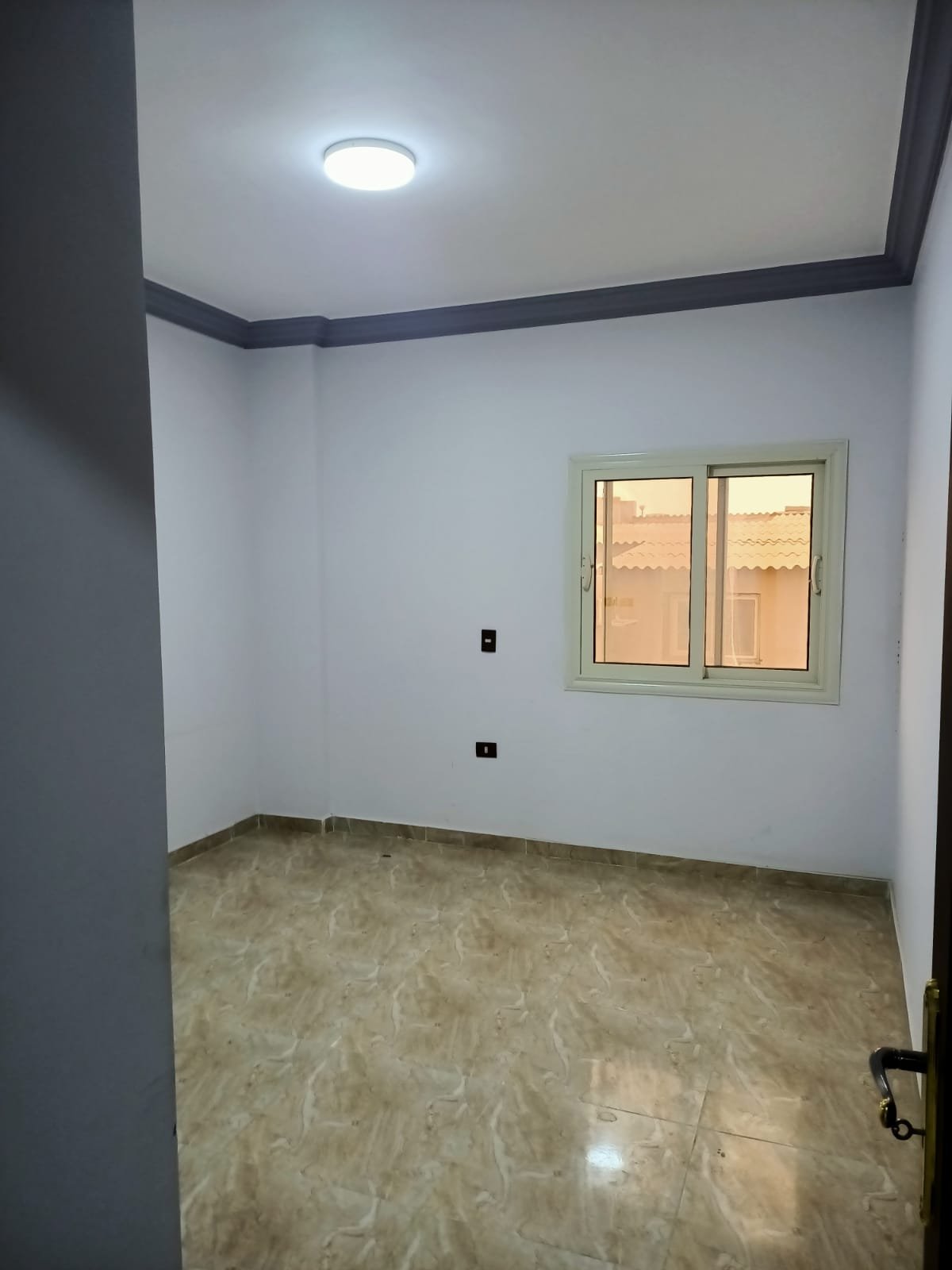 lotus-south-apt-223-ph1 Empty room with light blue walls and a ceiling spotlight - apartment in South Lotus on South 90th Street, New Cairo