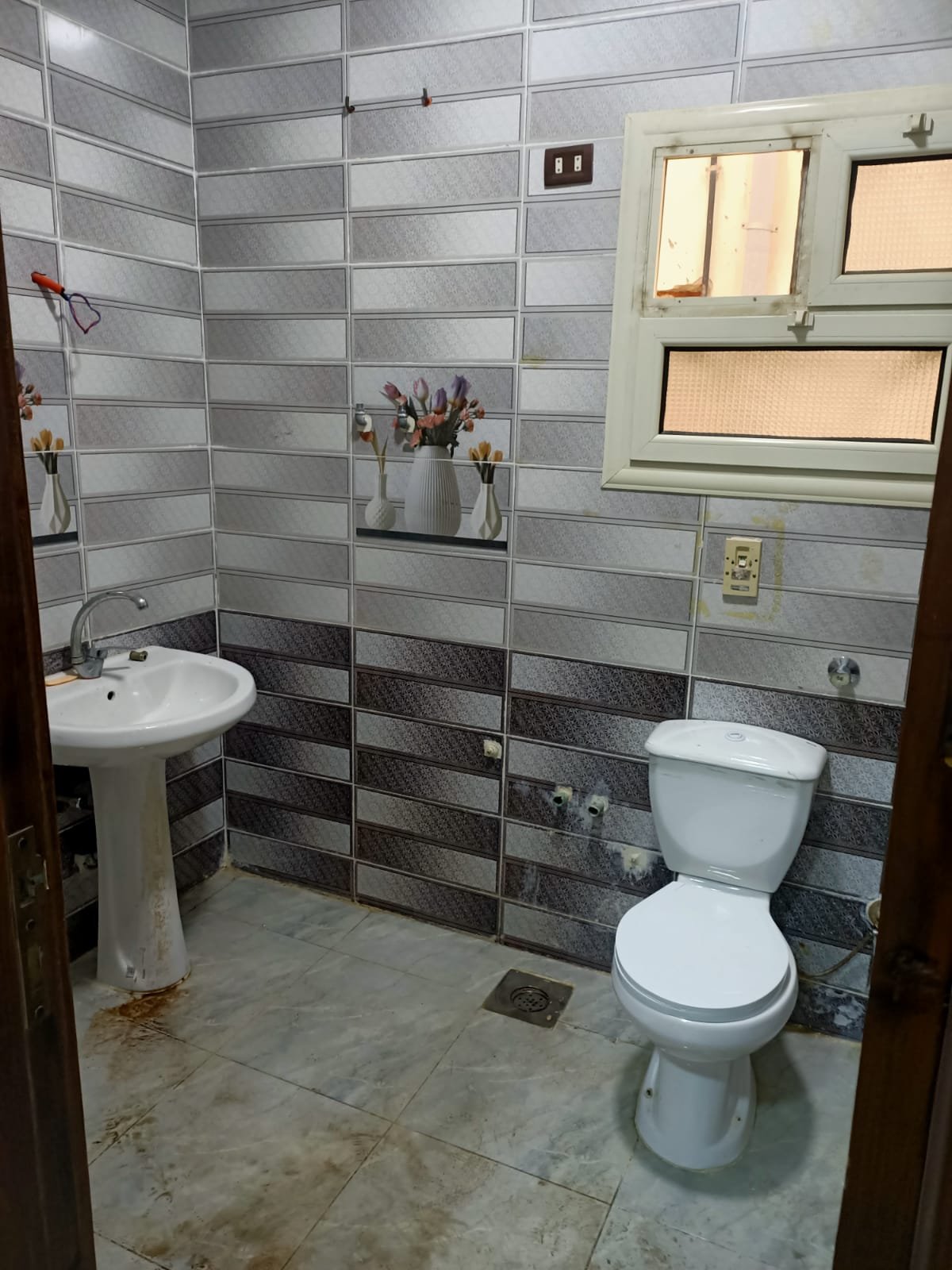 lotus-south-apt-223-ph2 Bathroom with grey and black wall tiles and a pedestal basin - apartment in South Lotus on South 90th Street, New Cairo