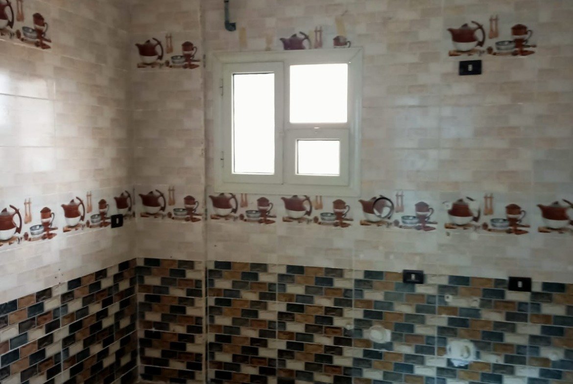 Empty bathroom with flower-border tiles and a small window - apartment in South Lotus on South 90th Street, New Cairo
