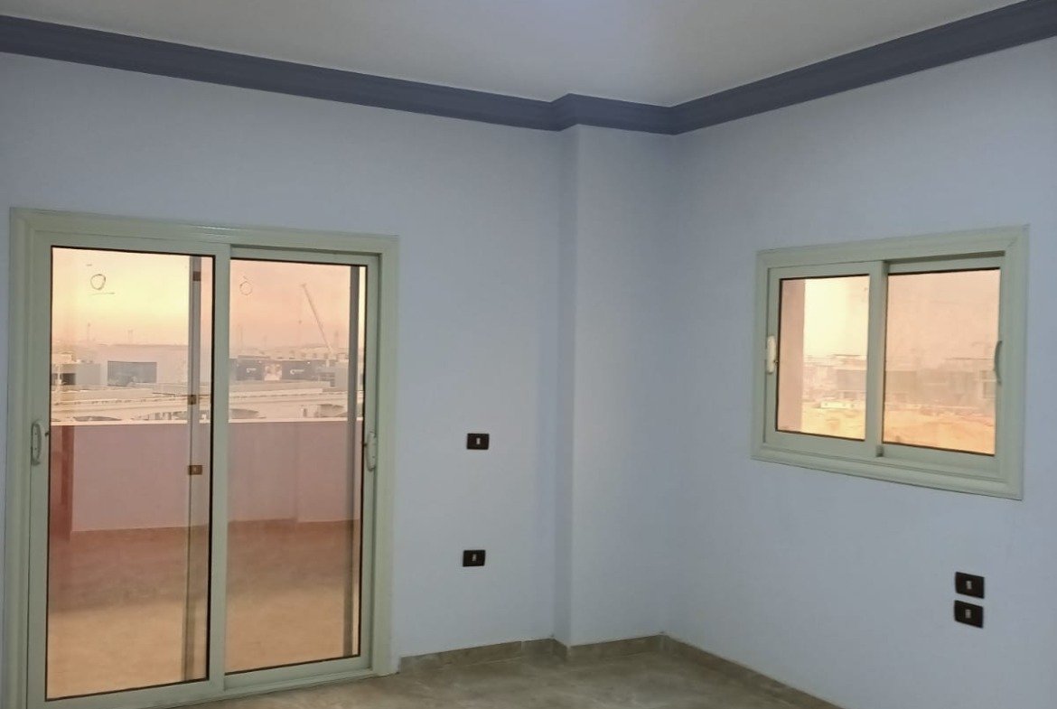 Empty room with a balcony door and a window - apartment in South Lotus on South 90th Street, New Cairo