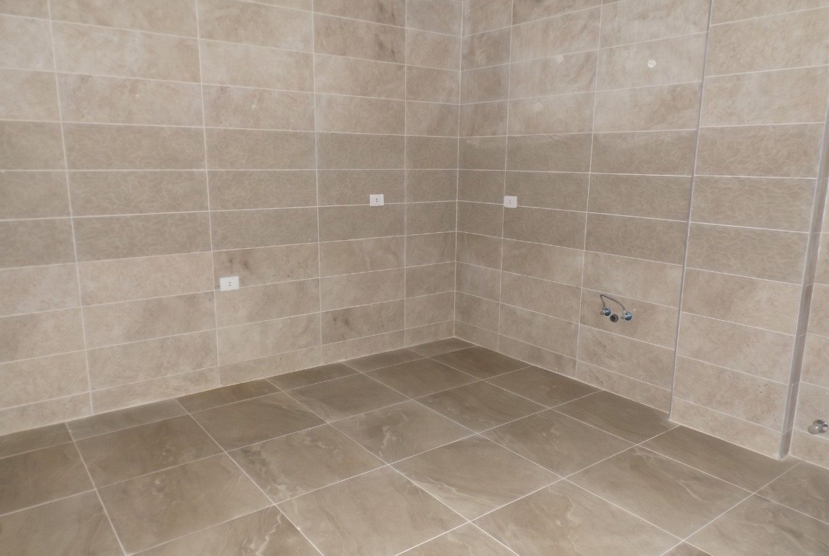 Empty kitchen with beige tiles - apartment in Moon Residence, Fifth Square, New Cairo
