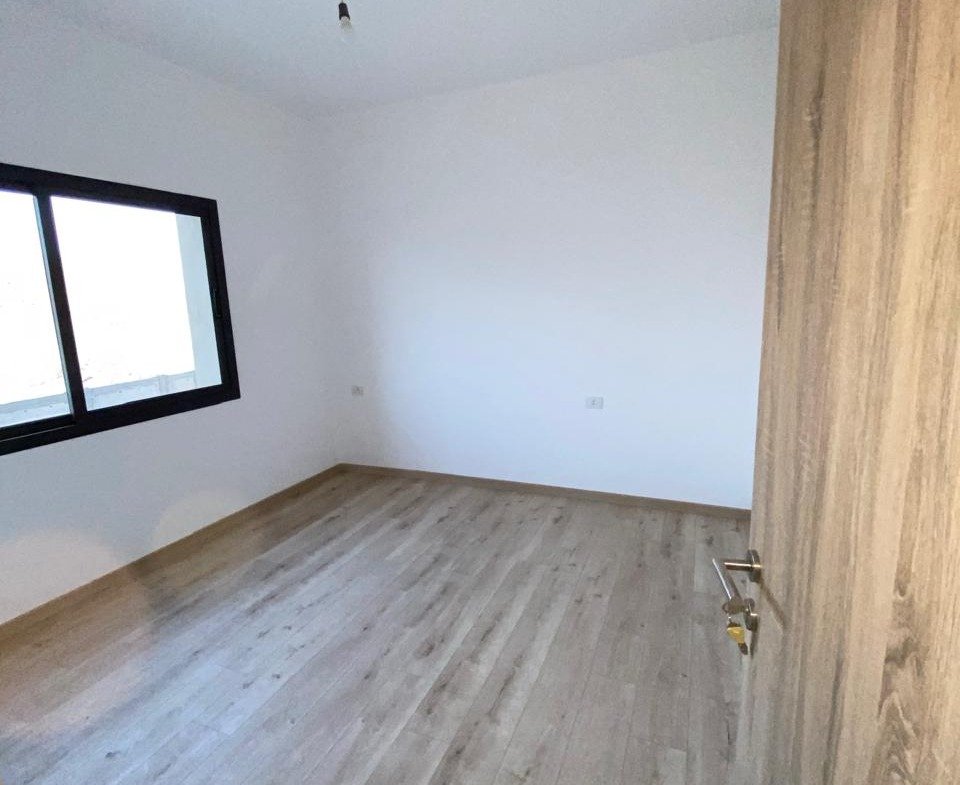 Empty bedroom with wooden floor and window - apartment in Moon Residence, Fifth Square, New Cairo