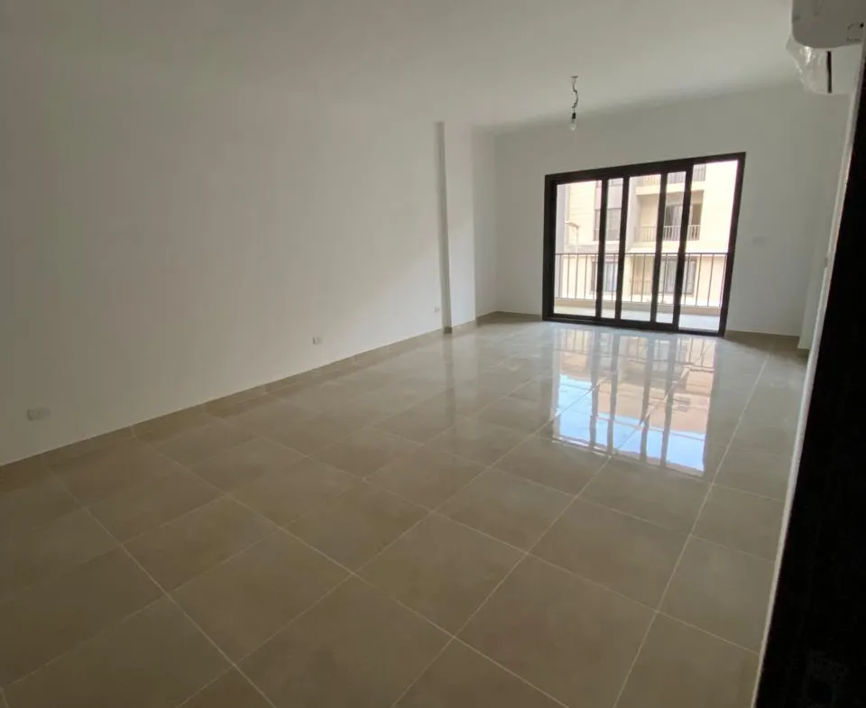 Empty living room with balcony door - apartment in Moon Residence, Fifth Square, New Cairo