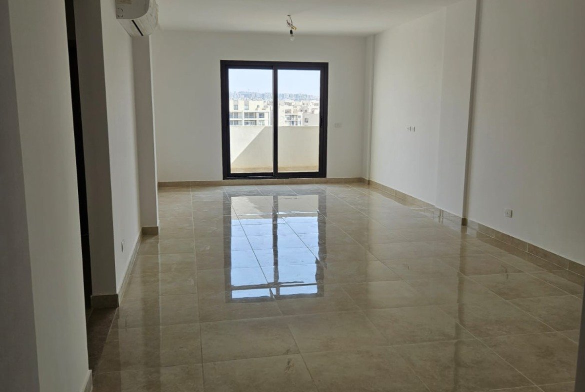 Empty living room with window and glossy floor - sky loft in Moon Residence, Fifth Square, New Cairo