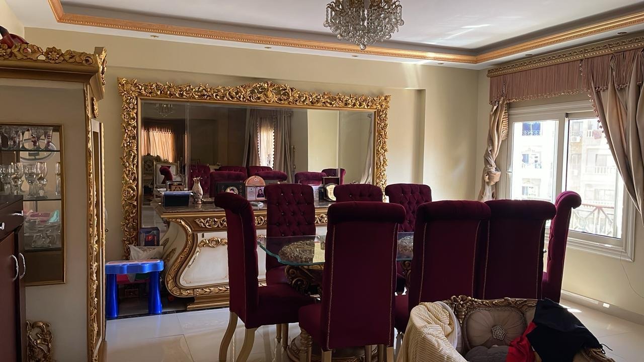 mostasharin-apt-221-ph4 Dining room with burgundy chairs, a gilded mirror and a chandelier - apartment in South Investors 2, 5th Settlement