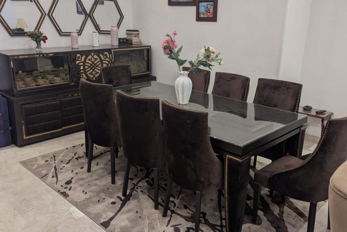 Dining table with dark chairs and a patterned rug - villa in Mountain View Hyde Park, New Cairo