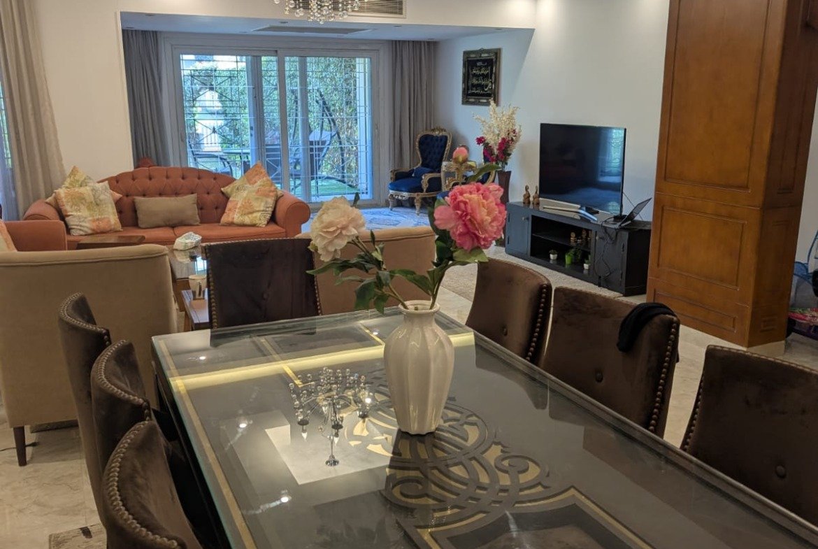 Glass-top dining table in a ground-floor living space - villa in Mountain View Hyde Park, New Cairo