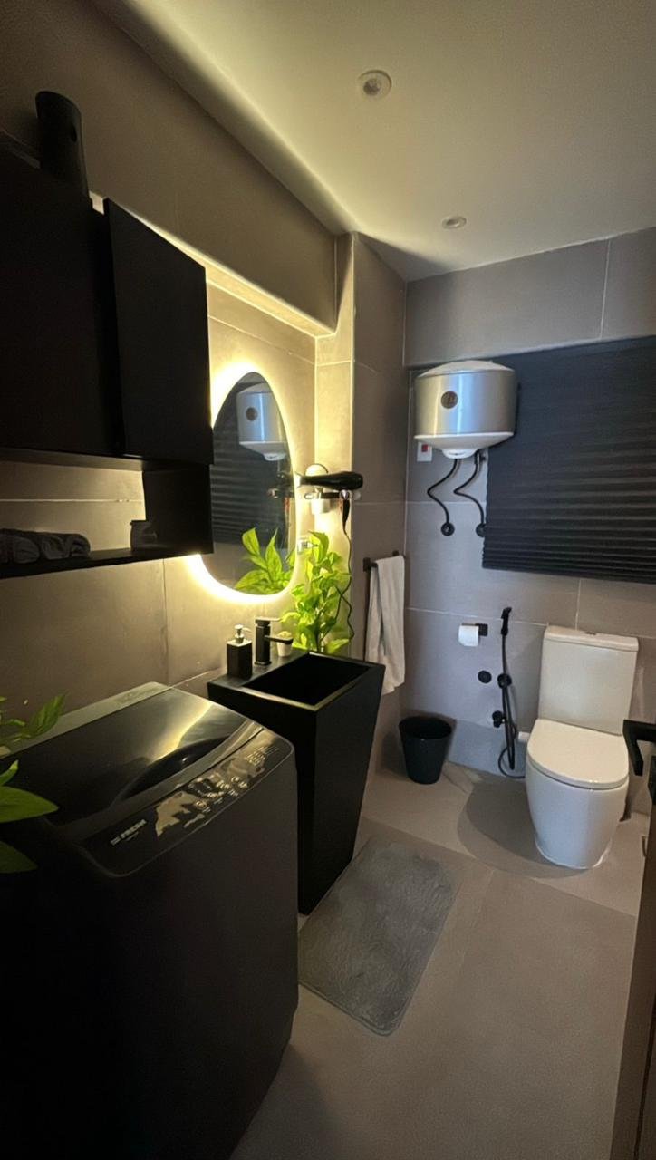 mvic525-u11 Black bathroom with a lit round mirror and wall-hung toilet - apartment in Mountain View iCity, New Cairo