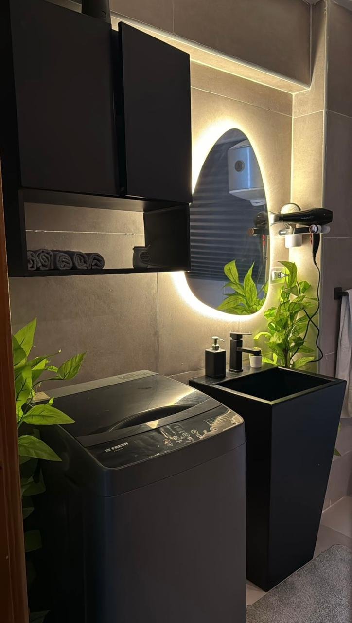 mvic525-u14 Dark vanity with an illuminated oval mirror and plants - apartment in Mountain View iCity, New Cairo