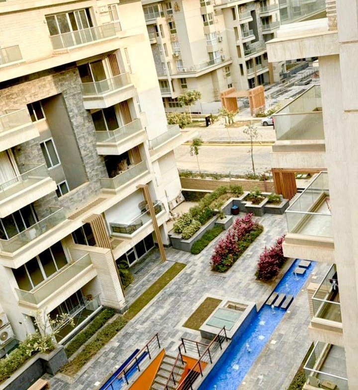 Courtyard with a blue water feature seen from above - apartment in Mountain View iCity, New Cairo