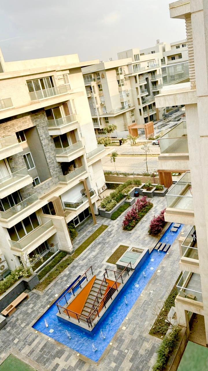 mvic525-u18 Courtyard with a blue water feature seen from above - apartment in Mountain View iCity, New Cairo