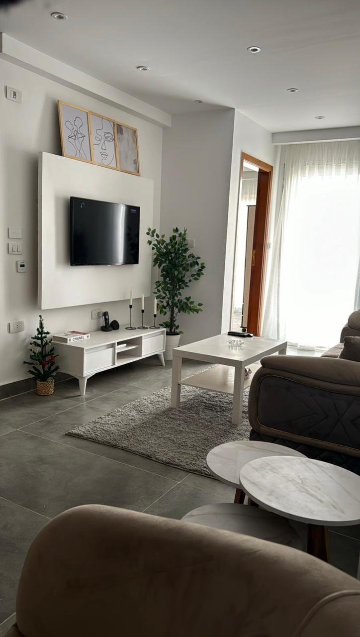 mvic525-u9 Living room with a wall TV unit and round tables - apartment in Mountain View iCity, New Cairo