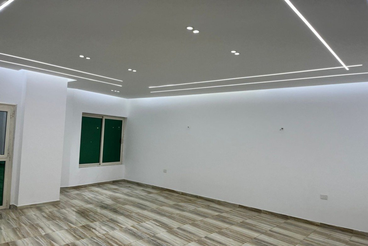 Corner of the reception with ceiling lines and a grey floor - unit in Marassi