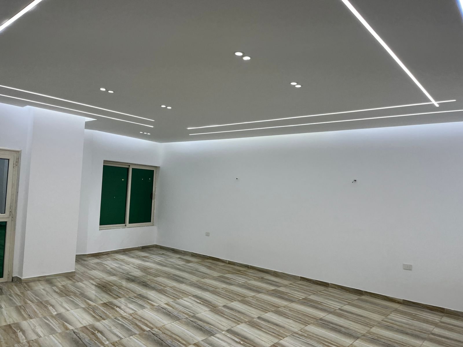 Corner of the reception with ceiling lines and a grey floor - unit in Marassi