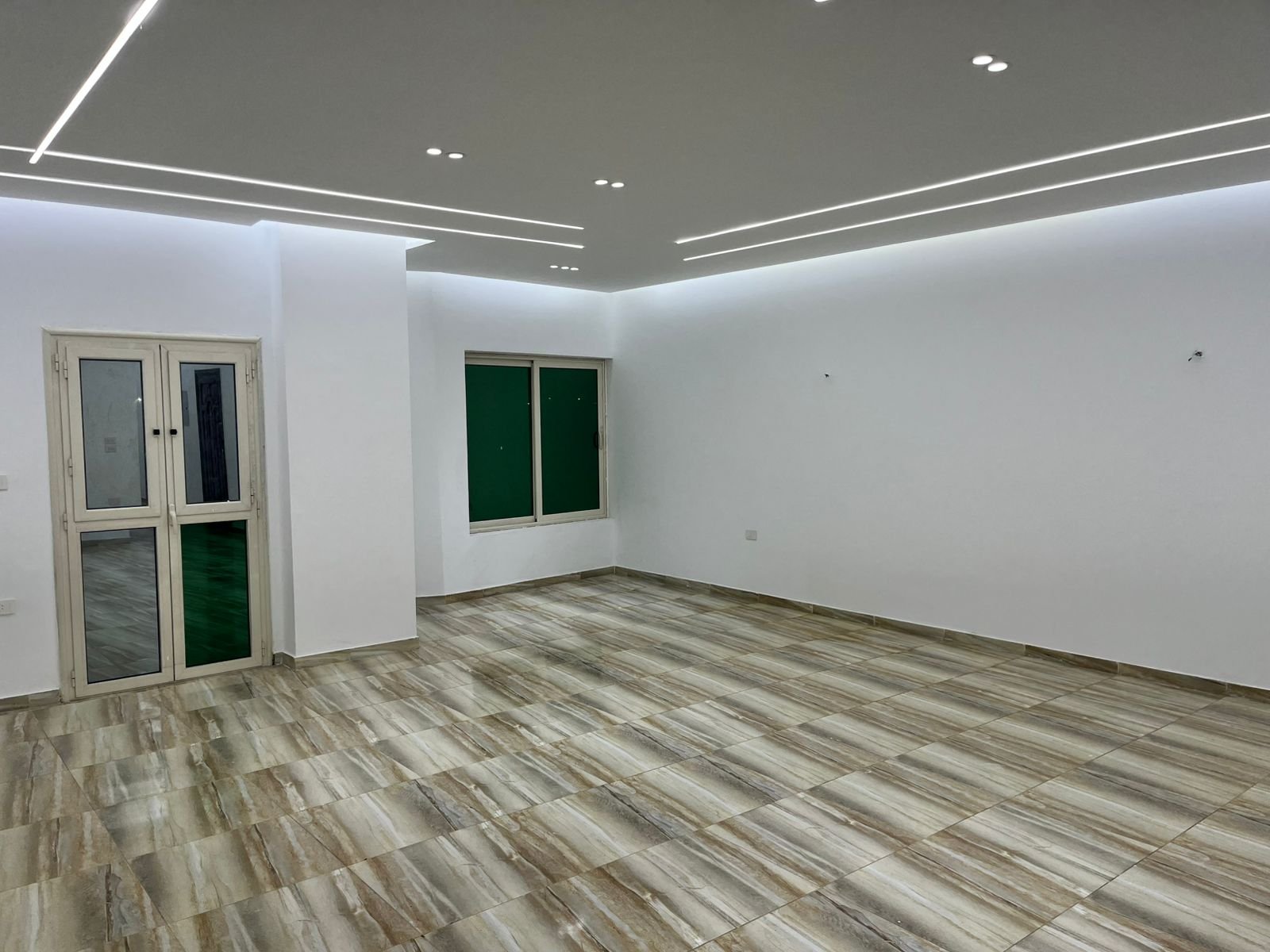Wide room with plank-look floor tiles and glass doors - unit in Marassi