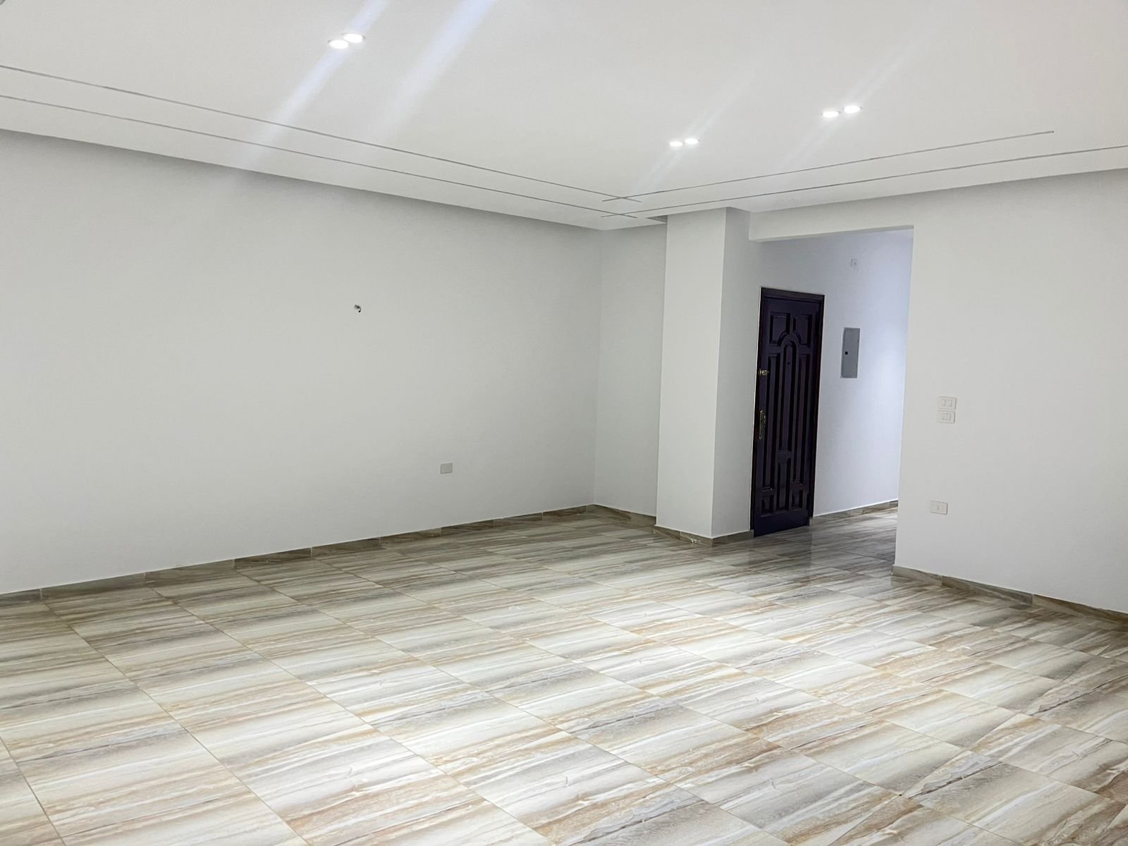 Empty room with white walls and a dark door at the back - unit in Marassi