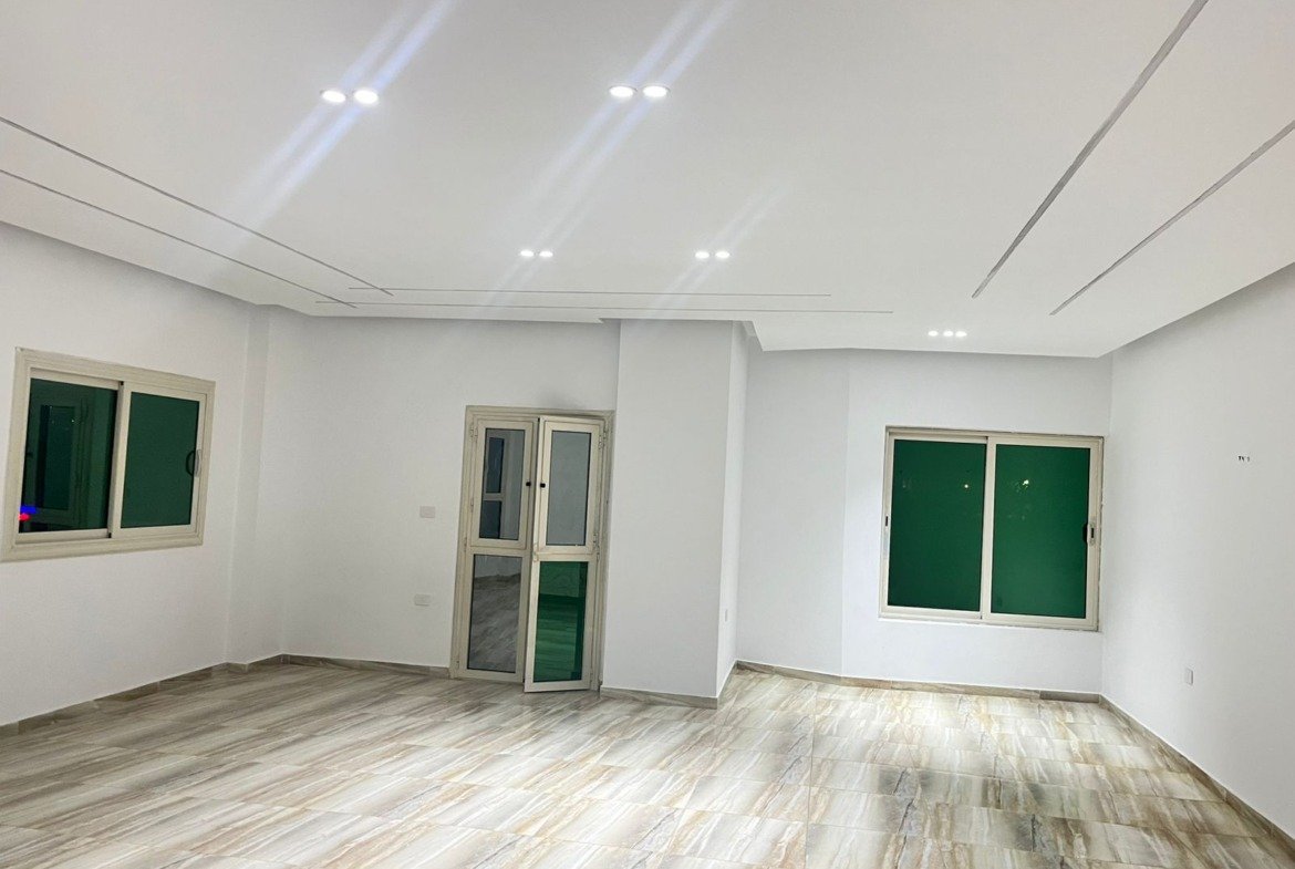 Reception facing two green-shuttered windows - unit in Marassi