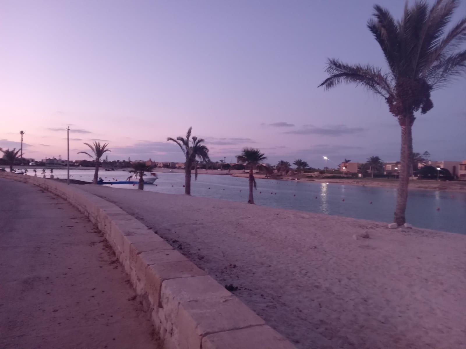 Palm-lined lagoon promenade at dusk - chalet in North Coast