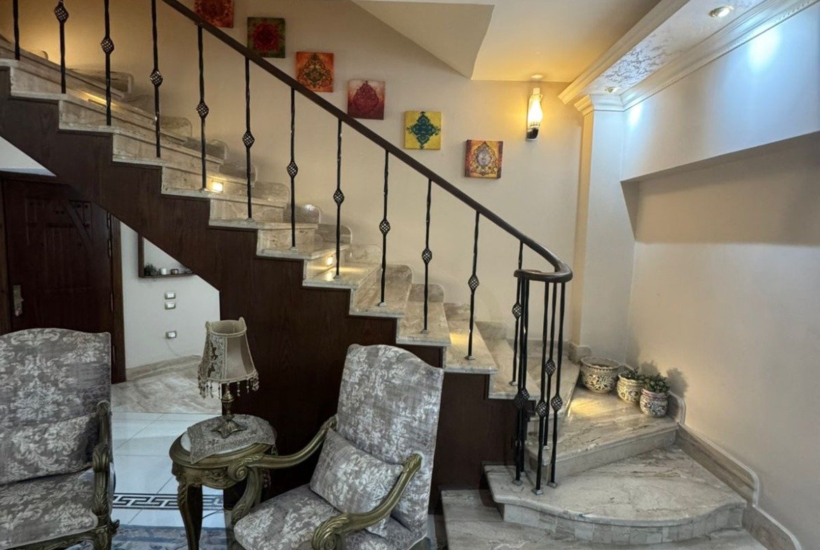 Staircase corner with armchairs and a blue rug - duplex in One Piece, New Cairo
