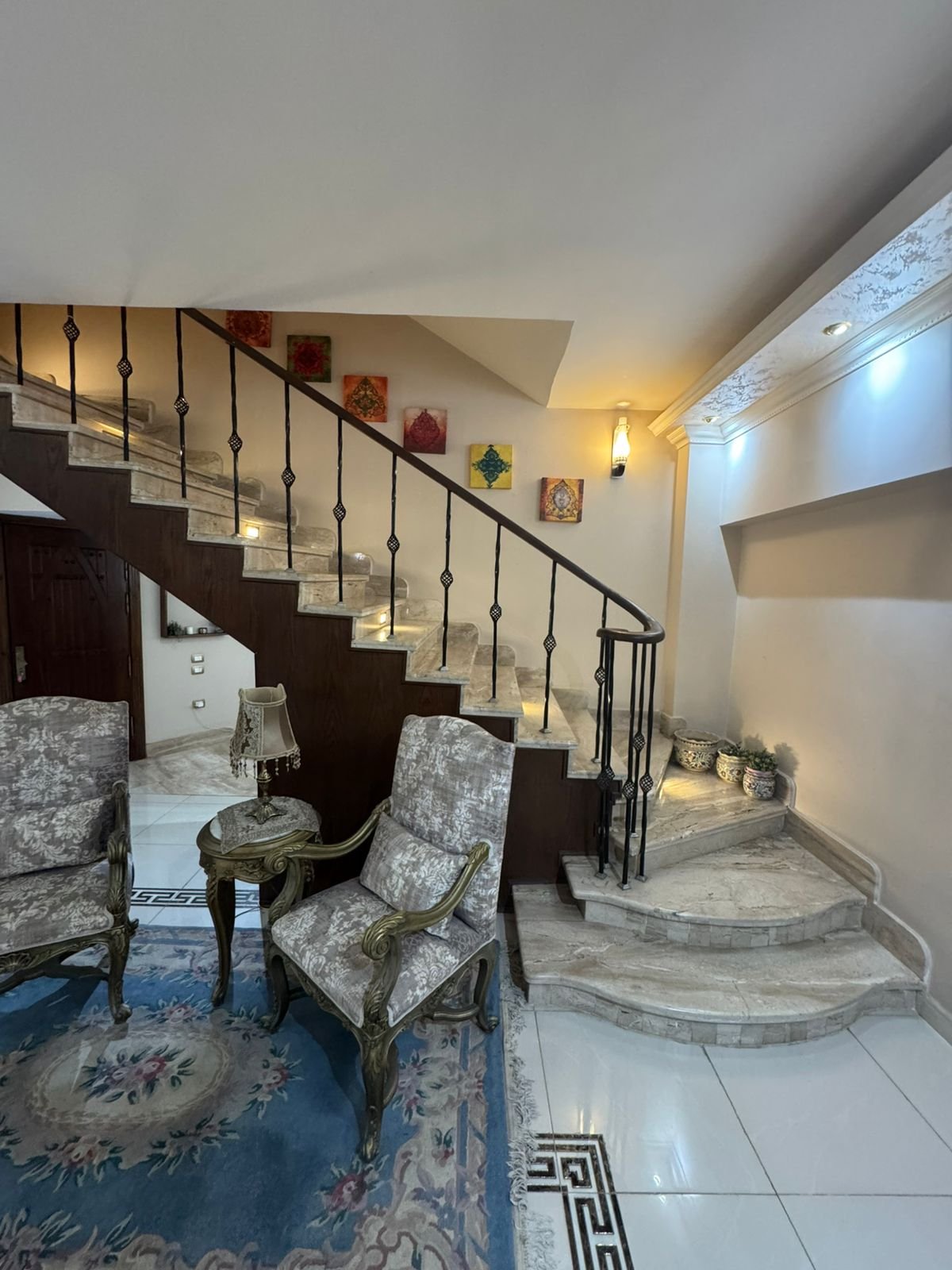 Staircase corner with armchairs and a blue rug - duplex in One Piece, New Cairo