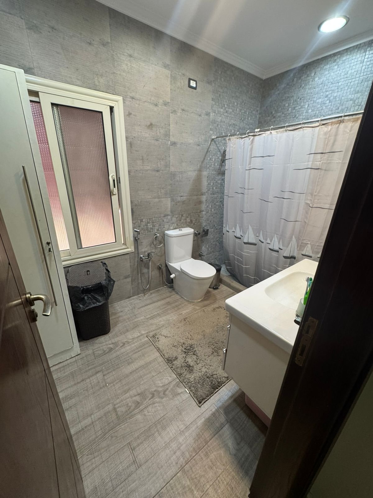 Bathroom with a toilet, a vanity and a curtain - duplex in One Piece, New Cairo