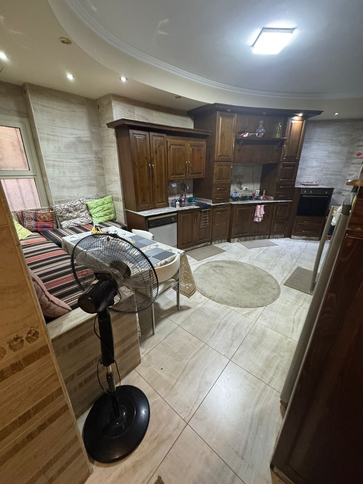 Open kitchen and sitting area with a standing fan - duplex in One Piece, New Cairo