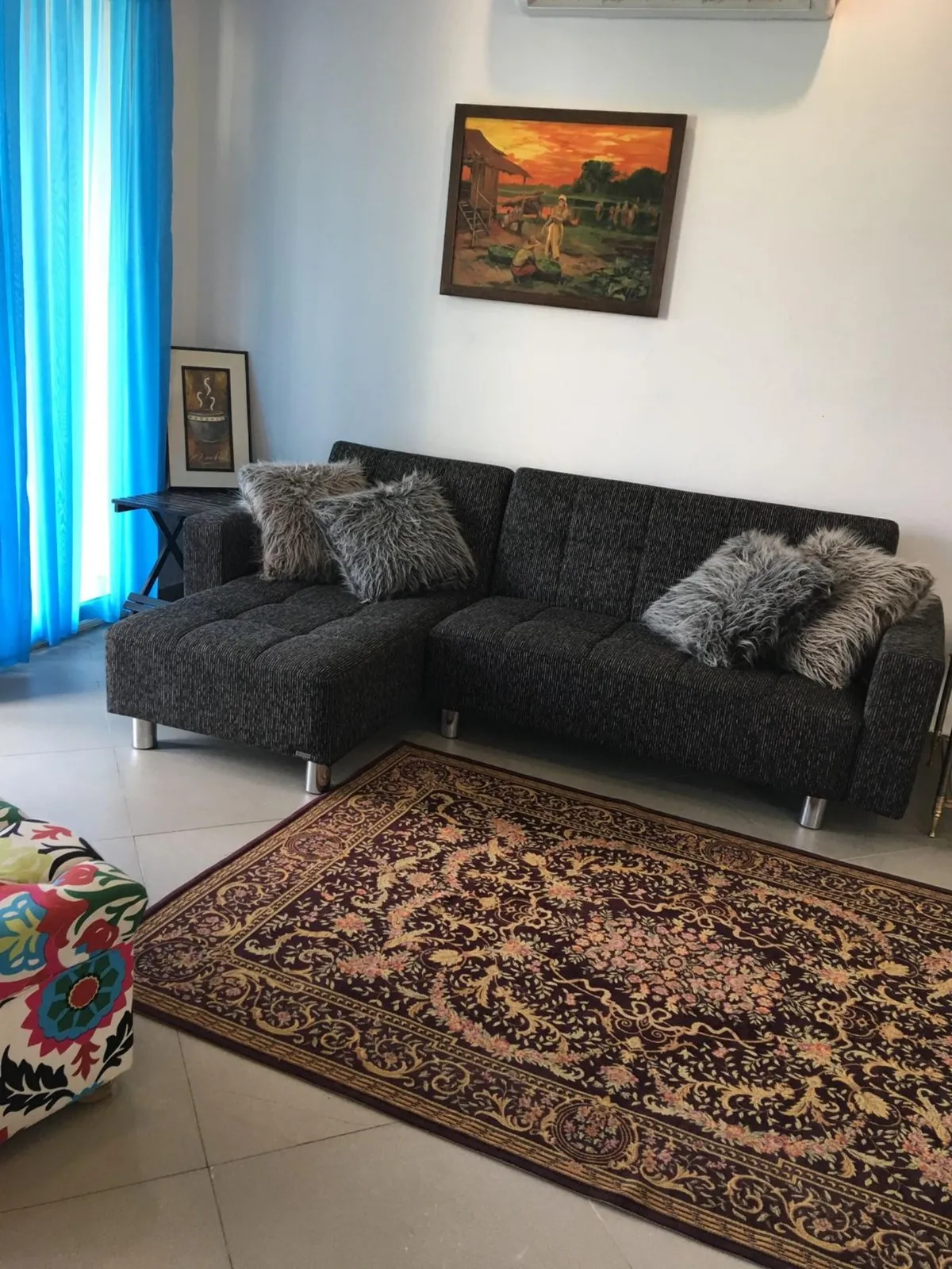 Living room with a black sofa and a patterned rug - apartment in Park View, New Cairo