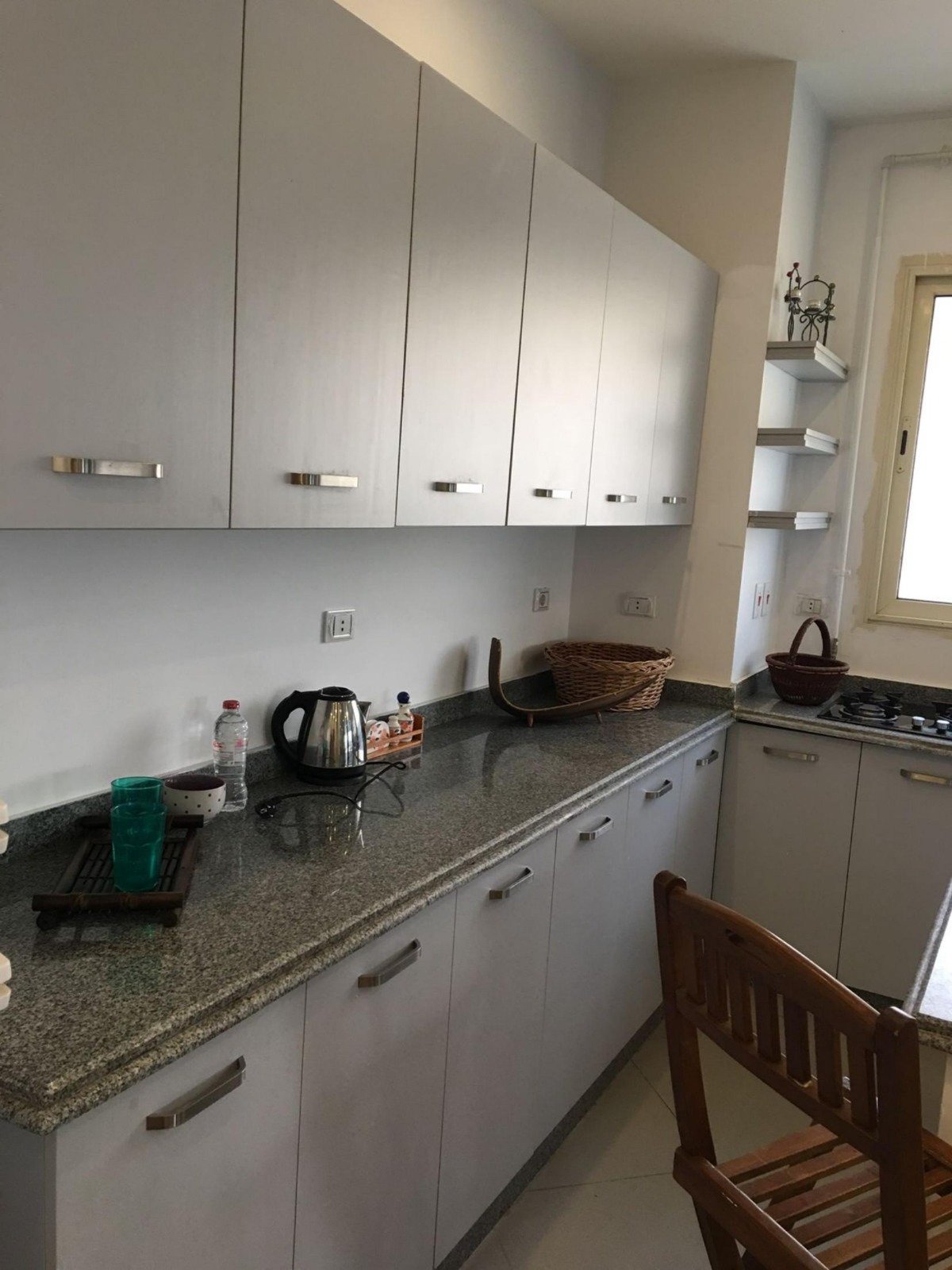 Kitchen with white cabinets and a granite counter - apartment in Park View, New Cairo