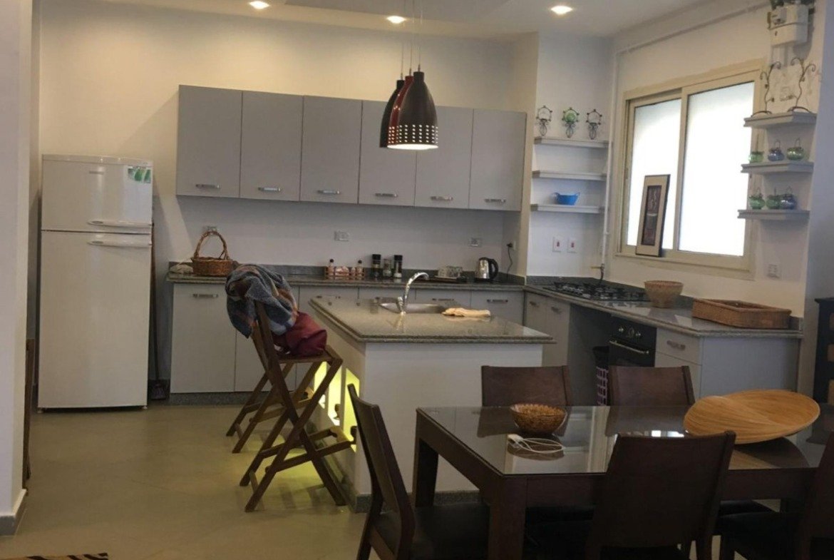Open kitchen and dining table seen from the living area - apartment in Park View, New Cairo