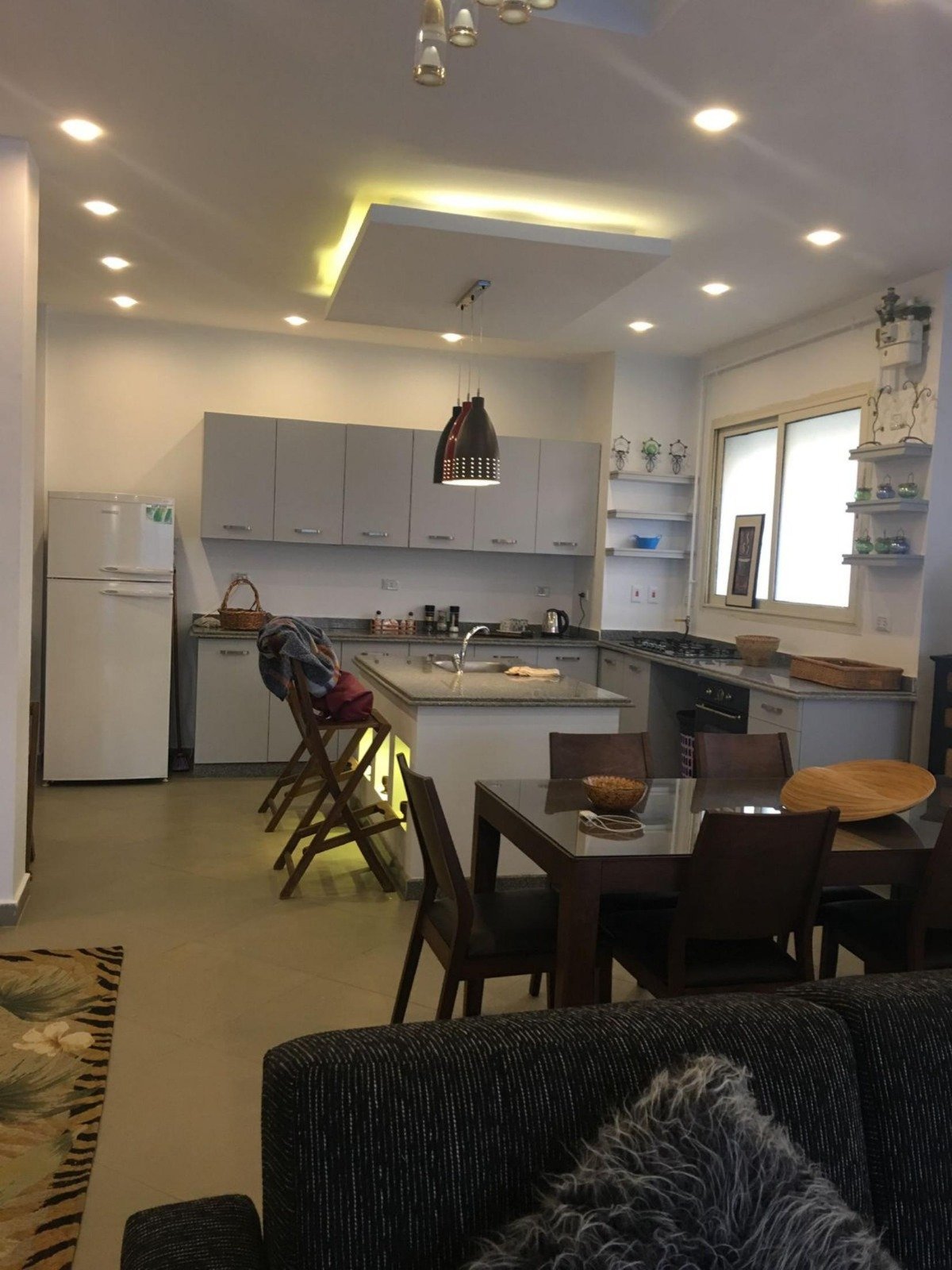 Open kitchen and dining table seen from the living area - apartment in Park View, New Cairo