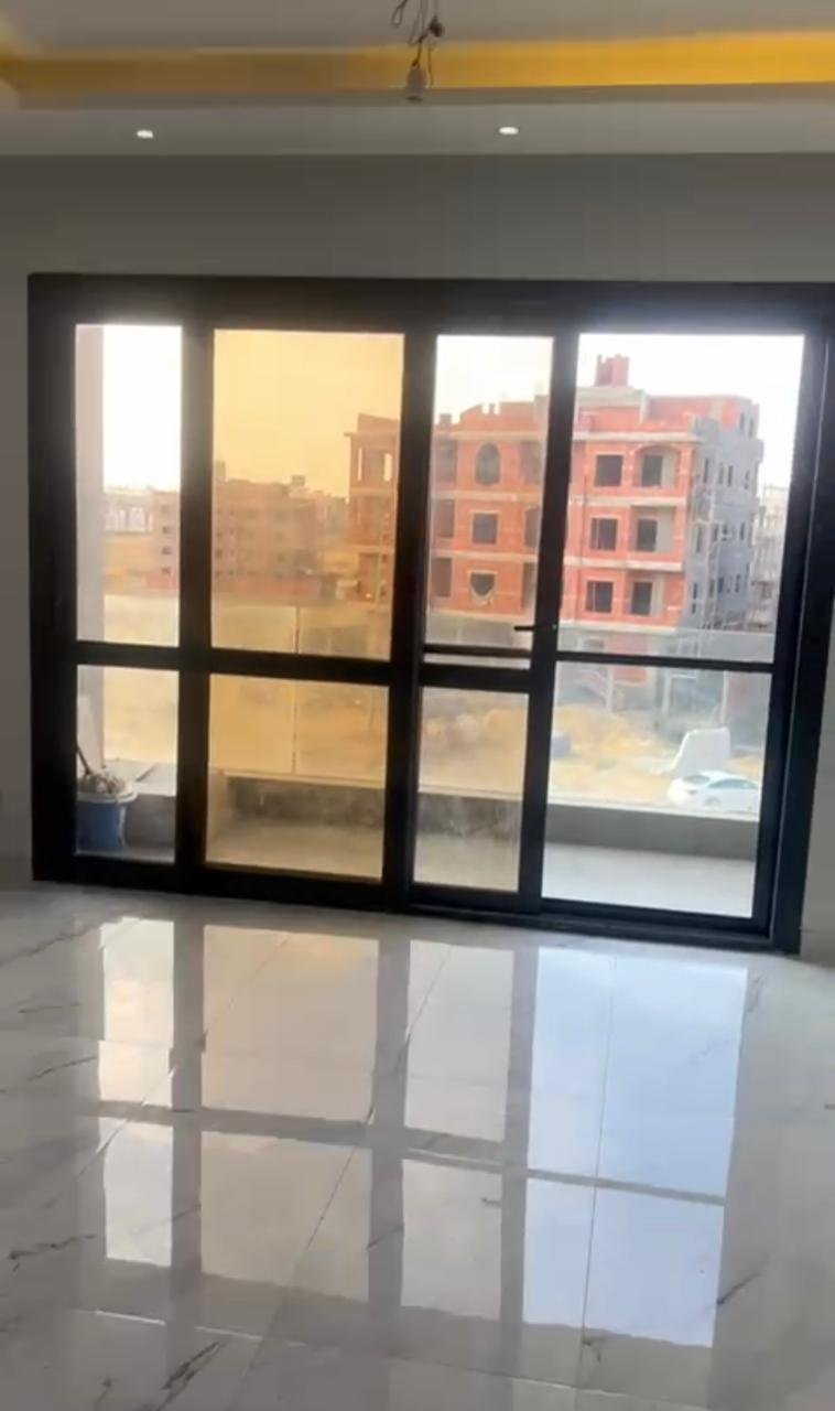 Large glass balcony doors with a sunset glow - apartment in El Patio Oro, New Cairo