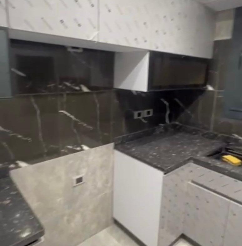 New kitchen with dark marble counters and grey wall tiles - apartment in El Patio Oro, New Cairo