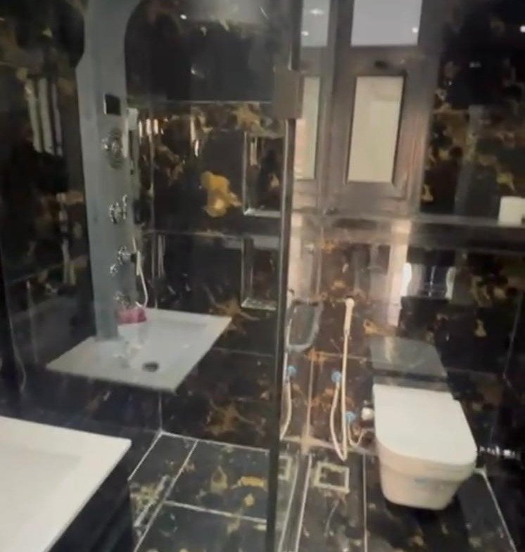 Bathroom with gold-veined black marble and a glass shower - apartment in El Patio Oro, New Cairo