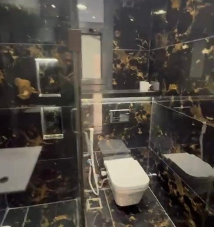 Bathroom with black and gold marble walls and a wall-hung toilet - apartment in El Patio Oro, New Cairo