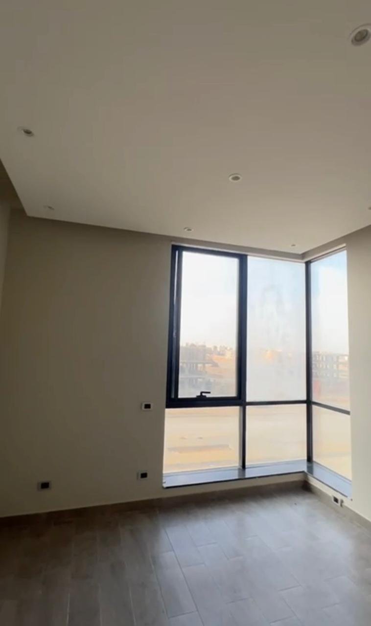 Empty room with floor-to-ceiling windows and a grey floor - apartment in El Patio Oro, New Cairo