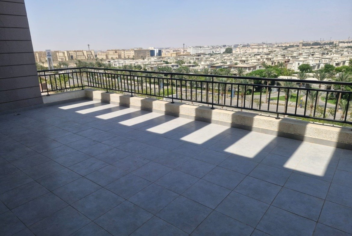 Wide terrace with a black railing and a skyline view - penthouse in Cairo Festival City, New Cairo