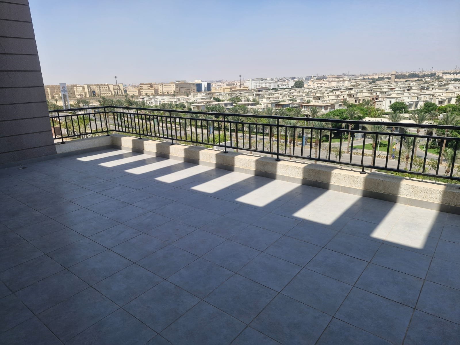 penthouse-for-rent-cfc-new-cairo-378-sqm-332-terrace Wide terrace with a black railing and a skyline view - penthouse in Cairo Festival City, New Cairo