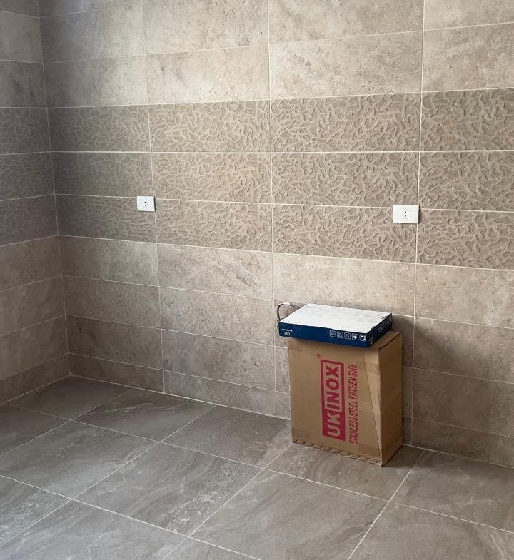 Empty kitchen with grey tiles - penthouse in Fifth Square, New Cairo