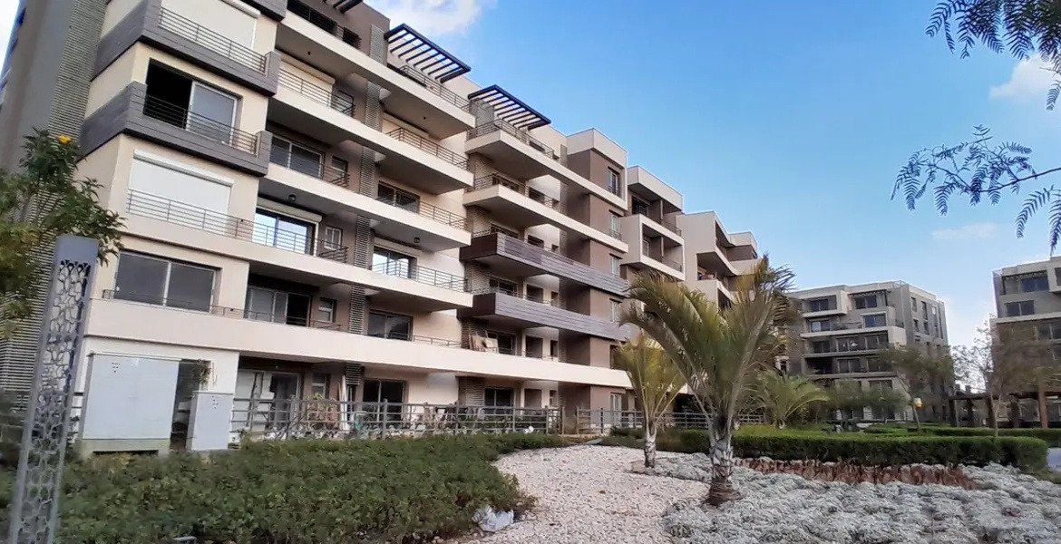Residential building with balconies behind palm trees - apartment in Palm Hills, New Cairo