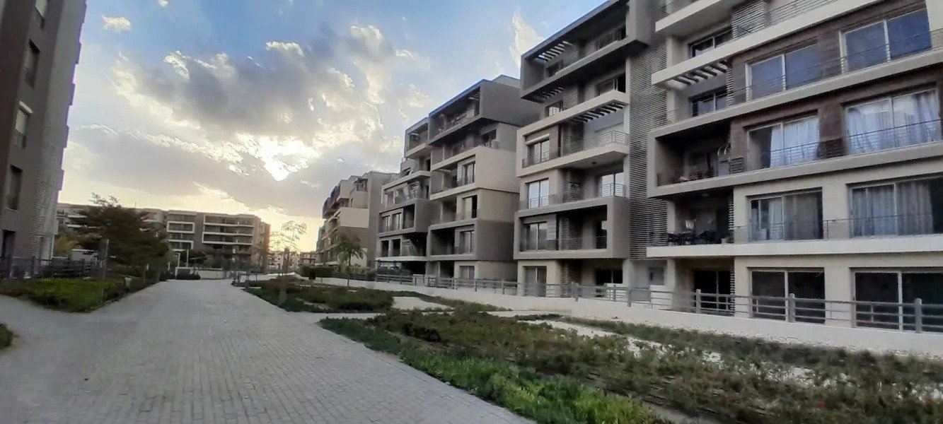phnc521-i04 Evening light over modern apartment blocks and a garden path - apartment in Palm Hills, New Cairo