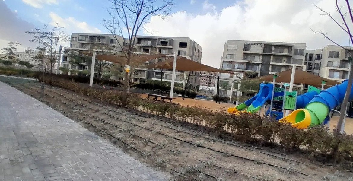 Children's slide playground beside a walkway - apartment in Palm Hills, New Cairo