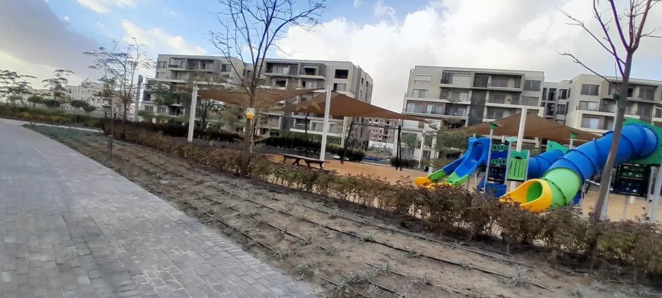 phnc521-i07 Children's slide playground beside a walkway - apartment in Palm Hills, New Cairo