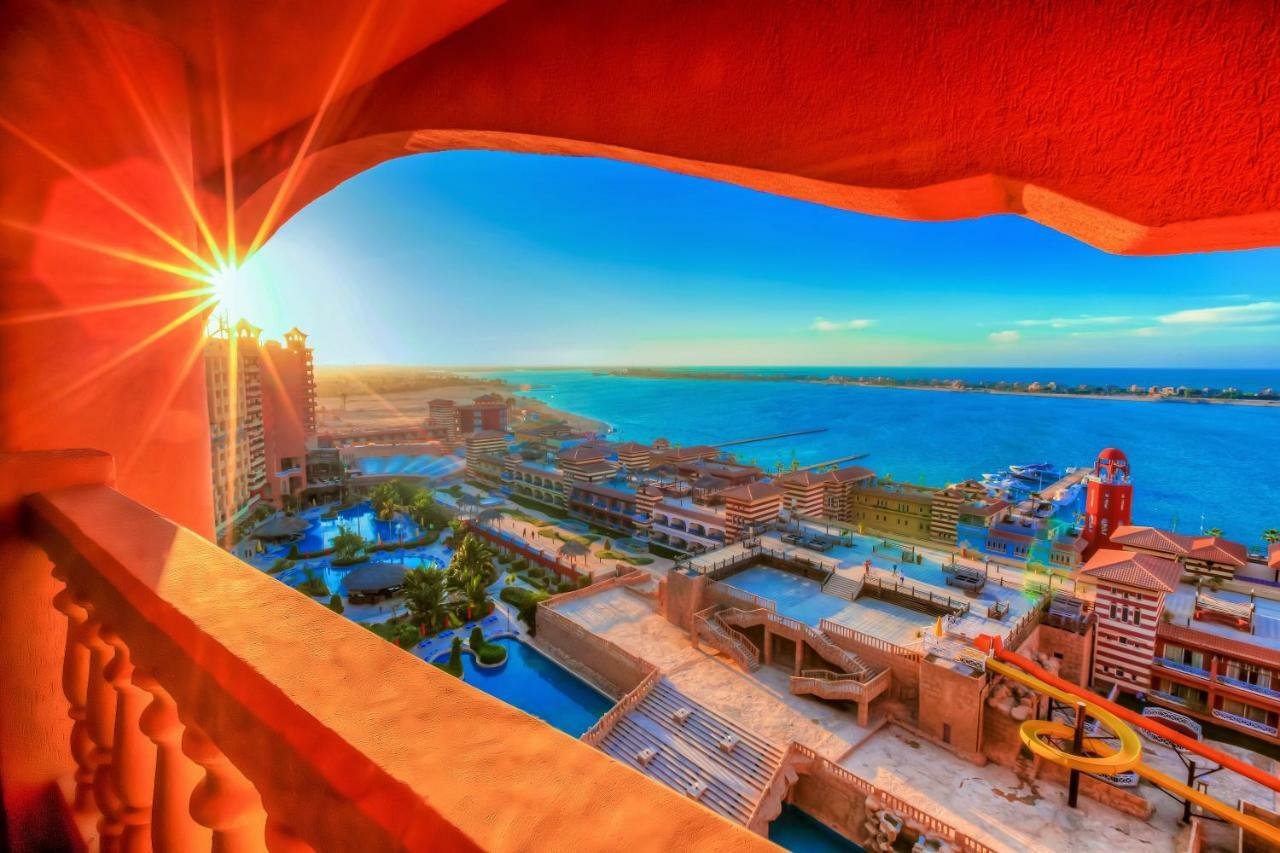 Sunburst view through a red balcony arch over the marina resort - chalet in Porto Marina, North Coast